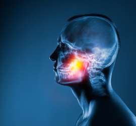 A man with an orange spot in his mouth.